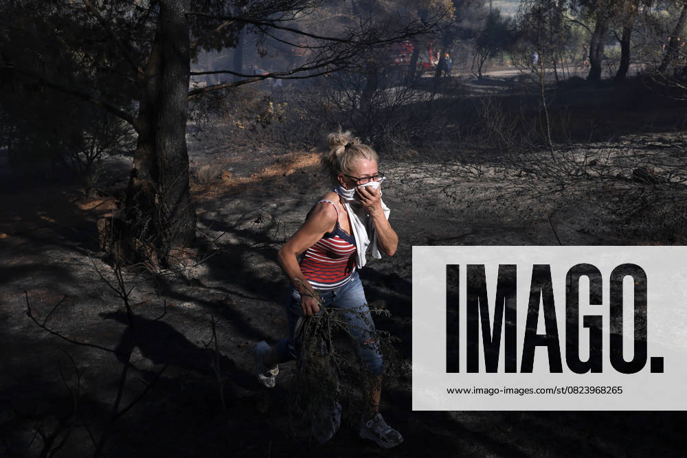 Wildfire near Athens damages homes, prompts evacuations ATHENS, GREECE - JULY 03: A woman covers her face during a wildfire in Pikermi, a suburb of Athens, Greece, on July 03, 2025. A wildfire broke out in the Pikermi area, about 30 kilometers from Athens, Greece, damaging at least five homes. Firefighters are battling the blaze from air and ground amid strong winds, while some nearby settlements have been evacuated. Costas Baltas Anadolu Athens Greece. Editorial use only. Please get in touch for any other usage.