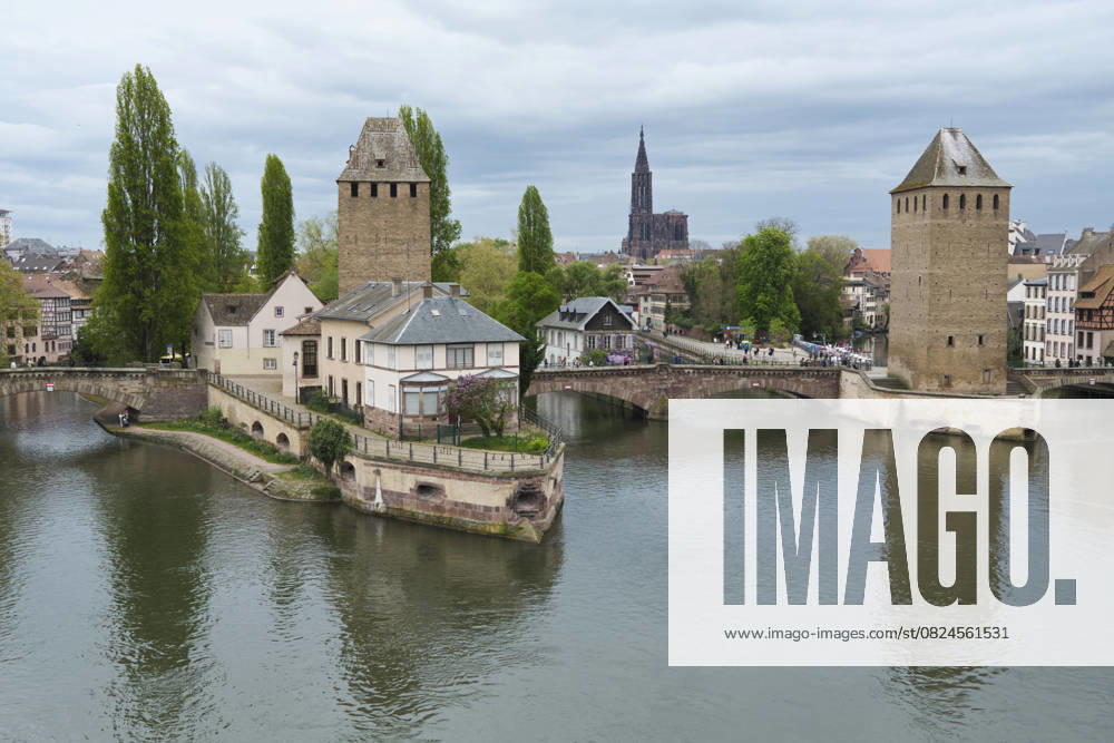 Historic stone towers and bridges over a calm river in a European town with lush greenery. Strasbourg, Grand Est region, France Strasbourg France bola08967