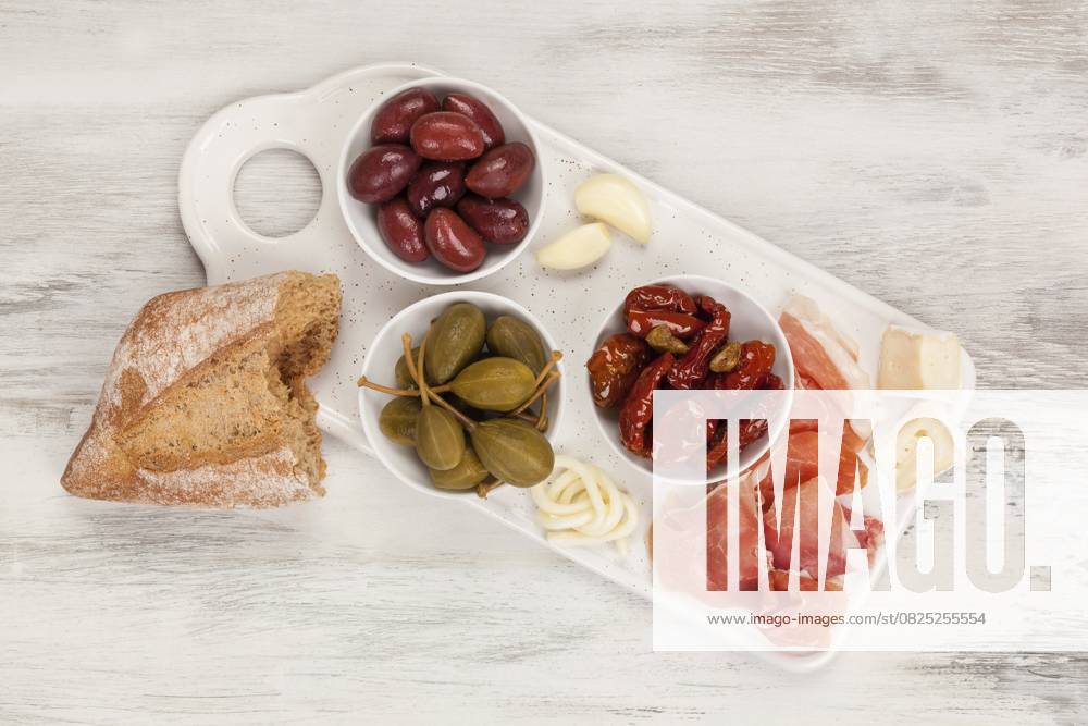IMAGO Creative, Food, Tapas Tapas von oben. Getrocknete Tomaten, Kapern, Oliven, Käse und Prosciutto Schinken. Italienisches Vorspeisen Konzept Tapas from above. Dry tomatoes, capers, olives, cheese and prosciutto ham. Italian appetizer concept