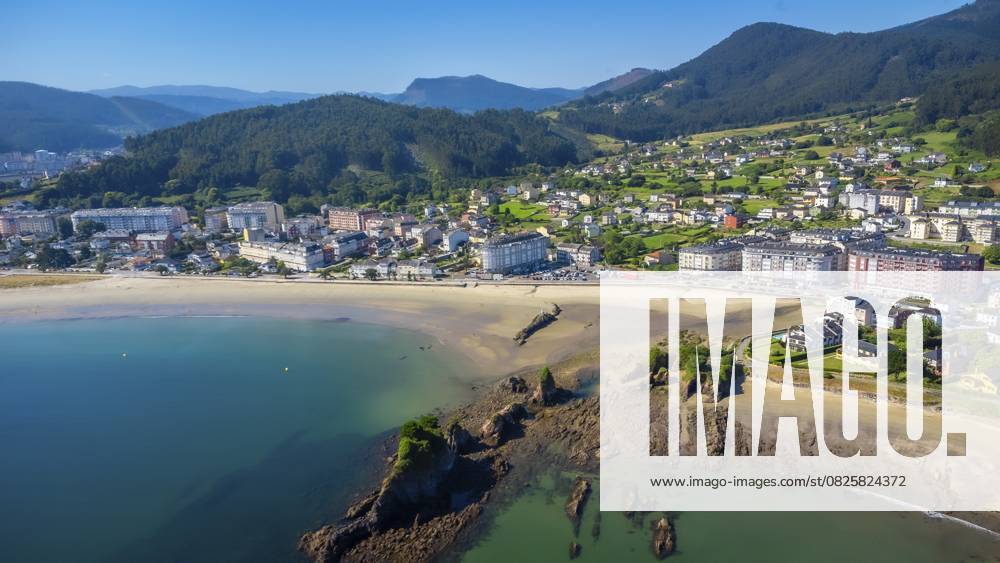 Luftaufnahme des Strandes von Covas, der auf das charmante Städtchen Viveiro trifft, das inmitten der atemberaubenden Landschaft von Galicien, Spanien, liegt und eine idyllische Küstenszene bildet Aerial view of covas beach meeting the charming town of viveiro, nestled amidst the stunning landscapes of galicia, spain, creating an idyllic coastal scene