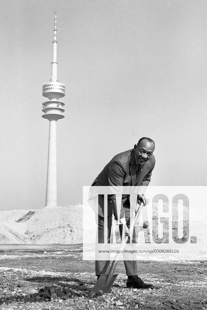 Jesse OWENS, USA, Leichtathlet, Sprinter, Weitspringer, Weitsprung, hier beim Olympiatreffen in München am 08.03.1969, SW-Aufahme, führt den ersten Spatenstich am Olympiagelände München aus, im Hintergrund der Fernsehturm, o0 Leichtathletik Olympiaturm