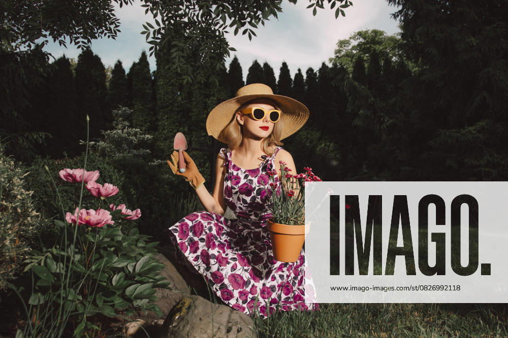 Stylish woman in retro dress gardening with flowers in spring garden model released, Symbolfoto, VSNF03487