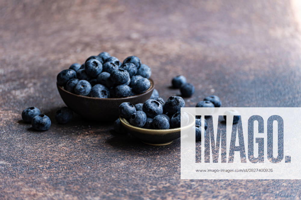 Fresh ripe blueberries in ceramic bowls on rustic surface A close-up image of fresh, ripe blueberries overflowing from ceramic bowls on a rustic surface. These nutrient-rich berries are packed with vitamins and antioxidants, ideal for a healthy diet Model Released AnnaBogush_ID30385_1025170_004