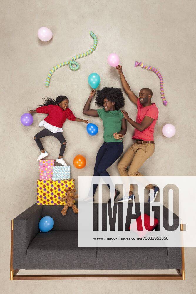 Little daughter celebrating birthday party, dancing with her parents model released Symbolfoto BAEF01582