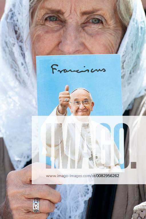 An elderly woman with a veil holds a picture of Pope Francis in her hands during the weekly general audience in St Peter s square at the Vatican.
