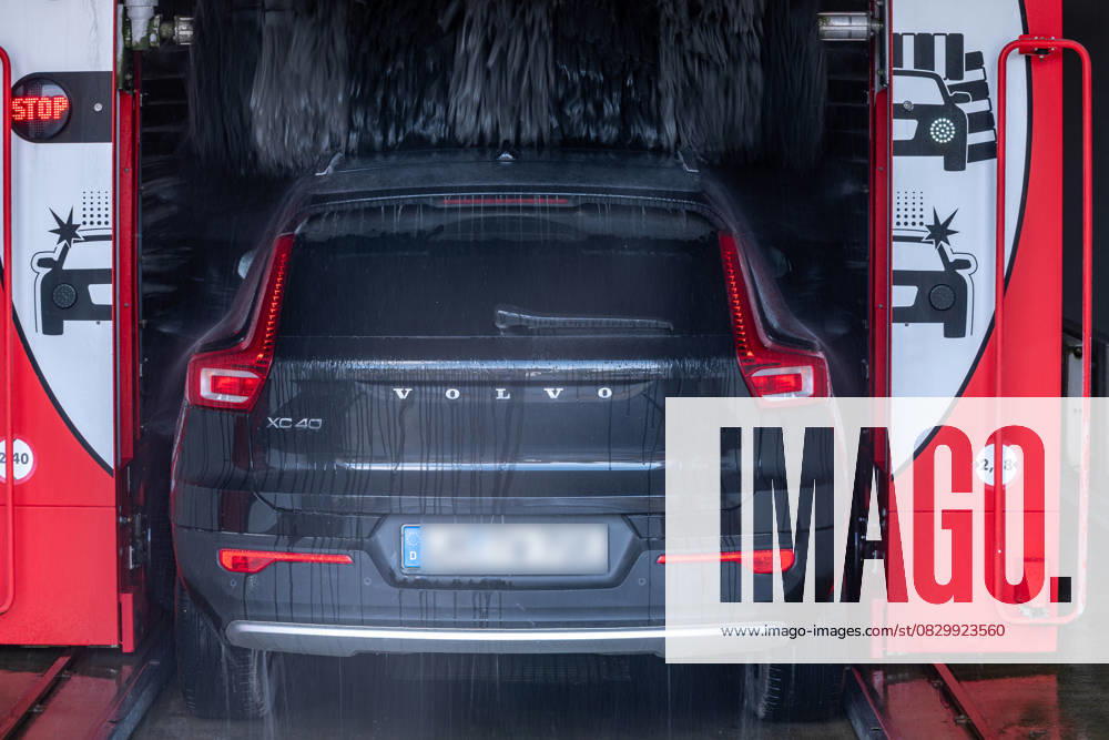 Volvo XC40 in automatischer Waschanlage 08.08.25, Selters: Symbolfoto, Illustrationsbild, Symbolbild, Illustrationsfoto, Alltagsszene Ein schwarzer Volvo XC40 fährt in eine rote WashTec-Autowaschanlage ein. Wasser sprüht von oben auf das Fahrzeug, während ein beleuchtetes Stop-Signal an der linken Seite sichtbar ist. Das Foto zeigt den Heckbereich des Fahrzeugs, aufgenommen in einer überdachten Waschstraße. Selters Hessen Deutschland
