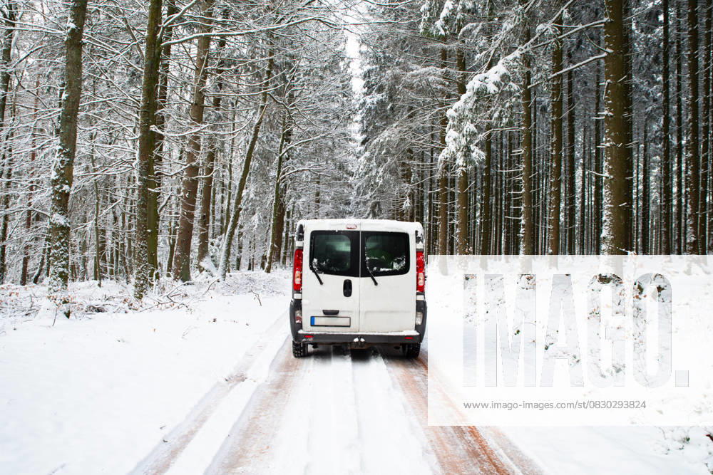 Wohnmobil auf einer Straße durch einen schneebedeckten Wald im Winter, Abenteuerurlaub und Lebensstil in den Wäldern, rutschige Autobahn