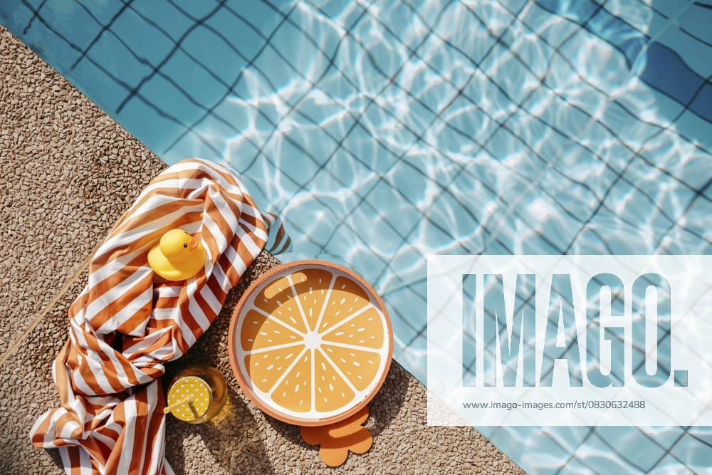 Poolrand mit orangen, sommerlichen Requisiten Pool edge with orange, summery props