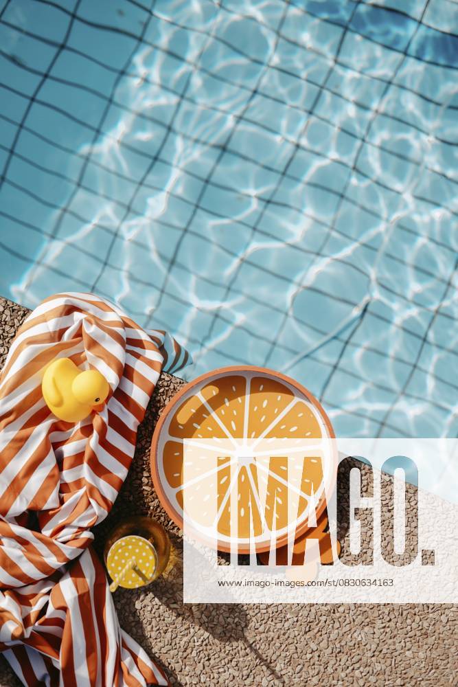 Poolrand mit orangen, sommerlichen Requisiten Pool edge with orange, summery props