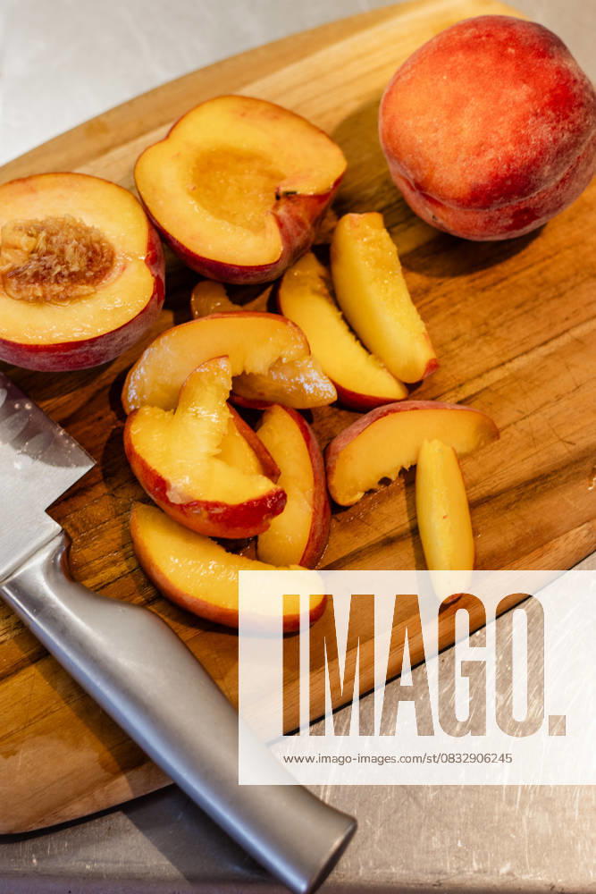 Freshly sliced peaches on a wooden cutting board Kelowna, British Columbia, Canada R_PESF2509050A-1816831-01