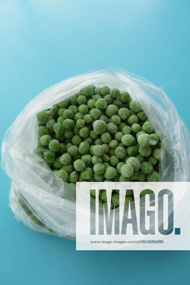 Frozen green peas packed in a clear plastic bag on a blue surface Fresh green peas are packed in a transparent bag on a blue background., 94833140.jpg RECORD DATE NOT STATED