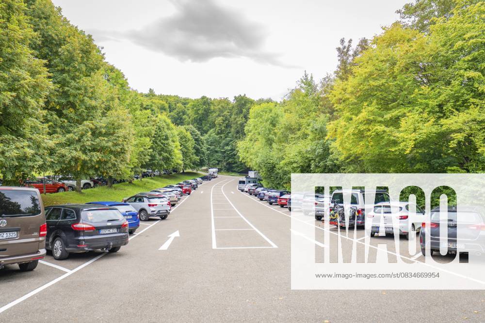 Ein langer Parkplatz, gesäumt von vielen Autos und üppigen grünen Bäumen, Schloss Lichtenstein, Lichtenstein, Schwäbische Alb, Deutschland A long car park, lined with many cars and lush green trees, Lichtenstein Castle, Lichtenstein, Swabian Alb, Germany