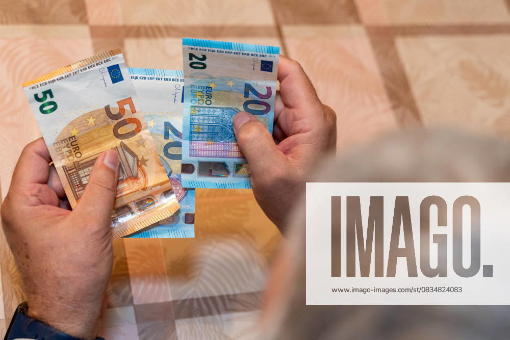 Ein alter Mann hält 50 und 20 Euro-Scheine in den Händen. Das Bild symbolisiert die finanzielle Sicherheit im Alter und steht für das Thema Rente, Altersvorsorge und den Bezug von Rentenzahlungen.