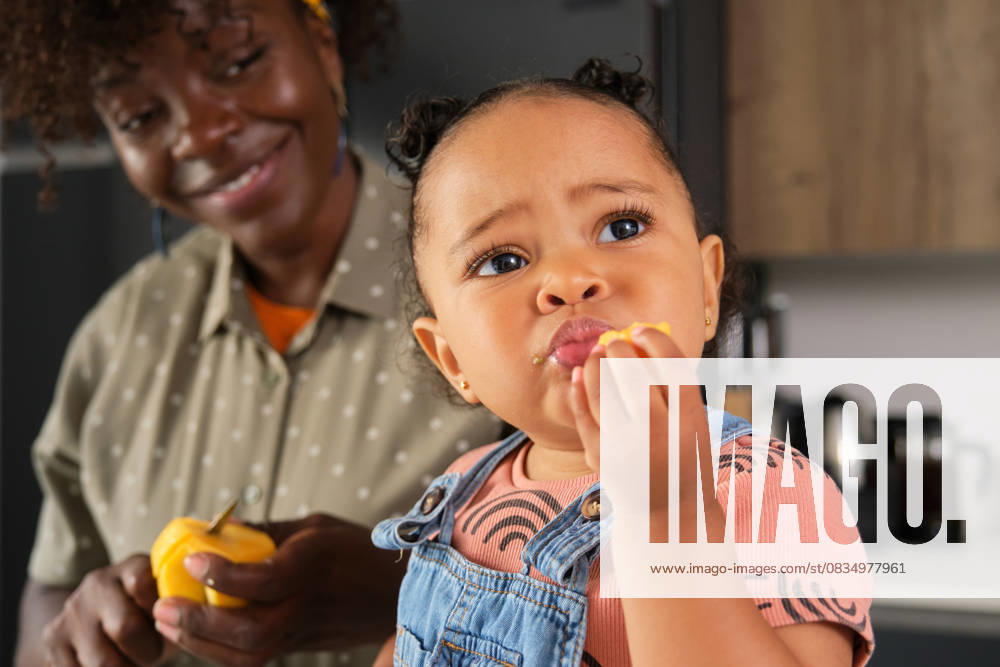 Toddler eating peach snack with mother at home kitchen model released, Symbolfoto property released, CVMF00115