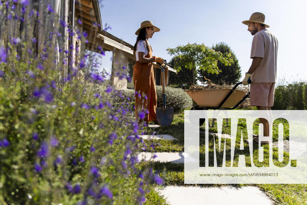 Couple gardening and collecting waste in eco garden near sustainable home model released, Symbolfoto property released, PCLF02593