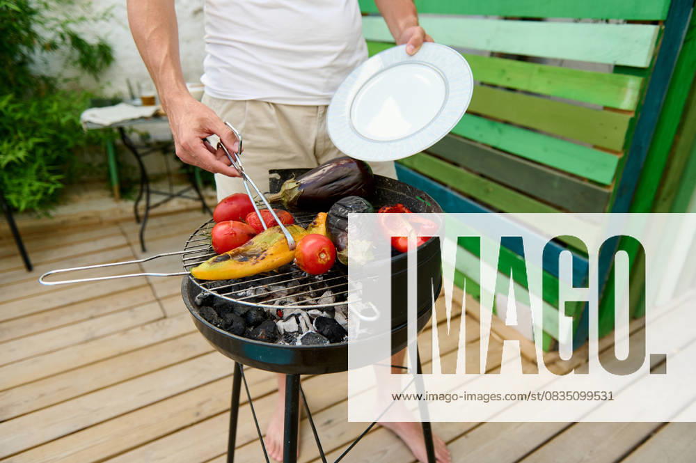 Man grilling vegetables on a backyard BBQ grill, preparing a healthy and delicious outdoor meal A man grilling assorted vegetables, including tomatoes, eggplant, and bell peppers, on a backyard BBQ. The scene captures a healthy and delicious outdoor meal preparation., model released, , property released, , 61018526.jpg RECORD DATE NOT STATED