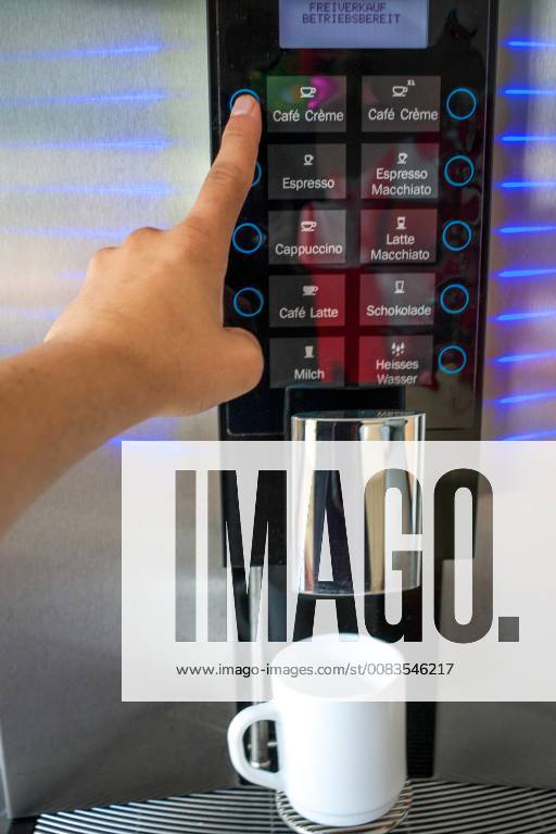 Männerhand bedient Kaffeeautomat in Büro, Taste Cafe creme. Tasse steht bereit für Kaffee Kaffeevollautomat in Büroküche