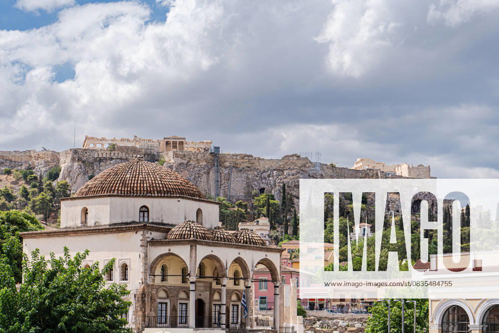 Athens cityscape with historic architecture and Acropolis Stunning view of Athens showcasing an ancient mosque, vibrant greenery, and the iconic Acropolis on a hill under a partly cloudy sky, highlighting Greece s rich history. Model Released AnnaBogush_ID31369_1066967_016