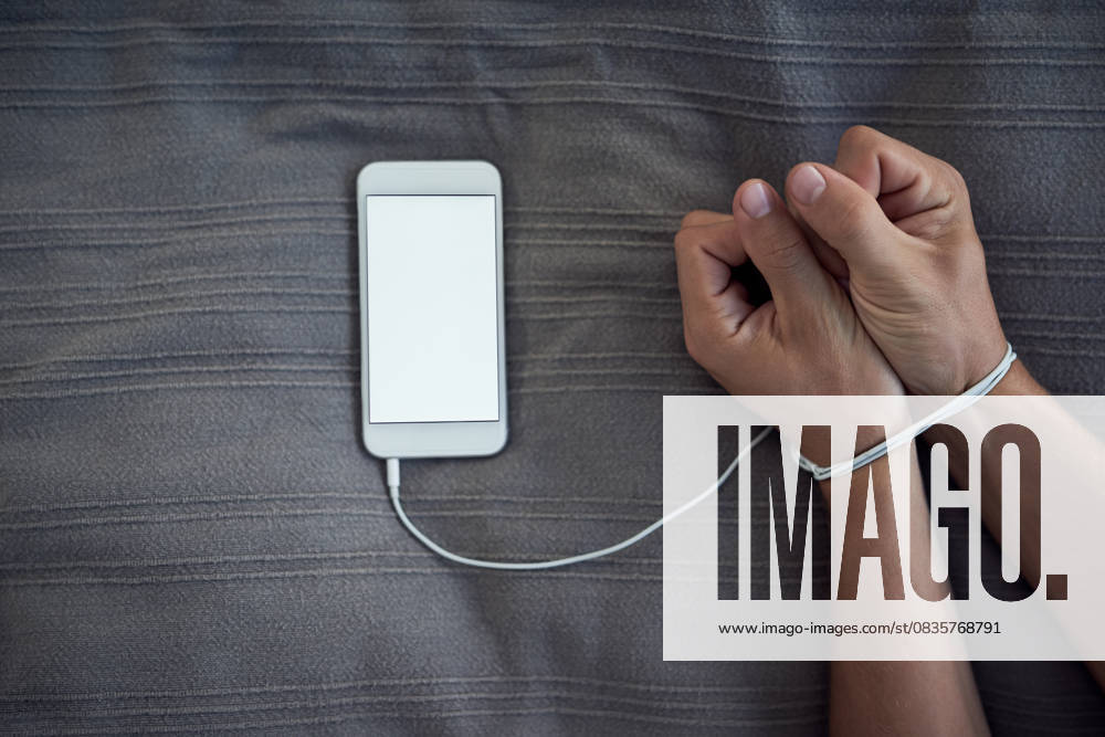 Phone screen, hands tied or internet addiction with cable handcuff on bed with above mockup for control in a house. Space, app or wrist with smartphone for network, social media and web manipulation Phone screen, hands tied or internet addiction with cable handcuff on bed with above mockup for control in a house. Space, app or wrist with smartphone for network, social media and web manipulation., model released, , 60345046.jpg RECORD DATE NOT STATED