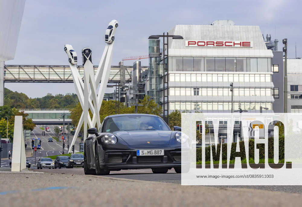 Porscheplatz, Stuttgart Zuffenhausen mit Porsche Hauptverwaltung. Kunstwerk Inspiration 911 von Gerry Judah: drei Stelen, die in bis zu 24 Metern Höhe je einen Porsche 911 präsentieren. Autotransporter mit Neuwagen. 29.09.2025: Stuttgart, Baden-Württemberg, Deutschland