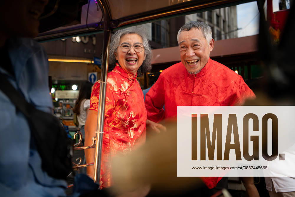 Ein glückliches älteres Paar in einem Chinatown in Bangkok, Thailand, A happy senior couple in a Chinatown in Bangkok, Thailand, using a local small car to explore the sights together, enjoying the city s transportation and lifestyle (License=RF) ,model released, Symbolfoto