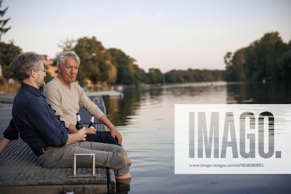 Senior friends sitting on pier with beer bottles near lake model released, Symbolfoto, JOSEF21713
