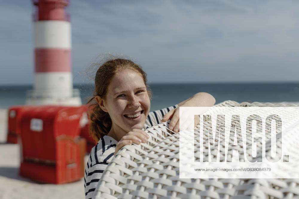 Smiling redhead at North Sea beach by lighthouse on Helgoland - Düne model released, Symbolfoto, MCHF00602