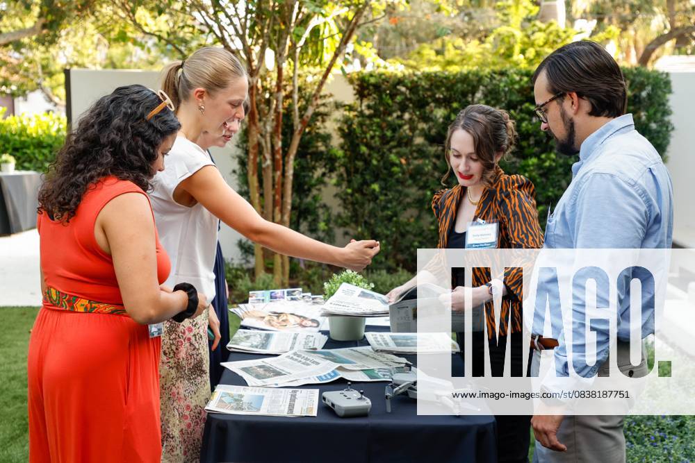 Tampa Bay Times newsroom staff, Colleen Wright, Nina Moske, Claire McNeill, Emily Mahoney, and Max Chesnes place newspapers on a table during the annual Cocktails and News fundraiser event on Thursday, Oct. 23, 2025, in St. Petersburg. St. Petersburg USA - ZUMAs70_ 20251023_zan_s70_057