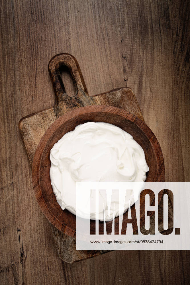 IMAGO Creative, Food, High Protein Frühstück saure Sahne in einer Holzschüssel, auf einem Holztisch, Draufsicht, Nahaufnahme, keine Personen, saure Sahne in einer Holzschüssel, auf einem Holztisch, Draufsicht, Nahaufnahme, keine Personen, (License=RF)