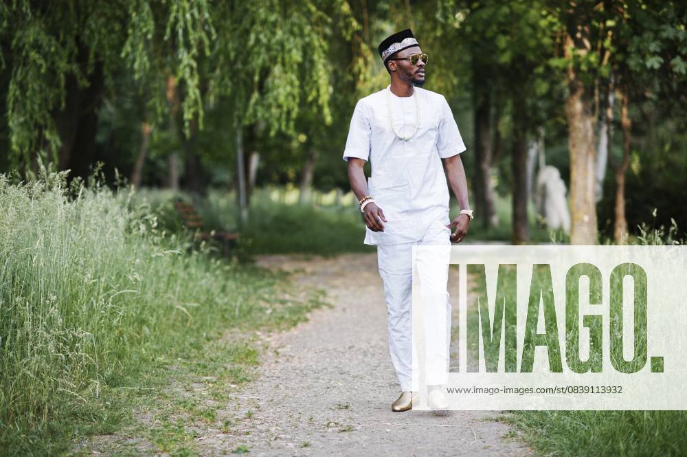 Porträt eines stilvollen und reichen schwarzafrikanischen Amerikaners auf weißer Kleidung, Sonnenbrille und Hut Portrait of stylish and rich black african american man on white clothes, sunglasses and hat