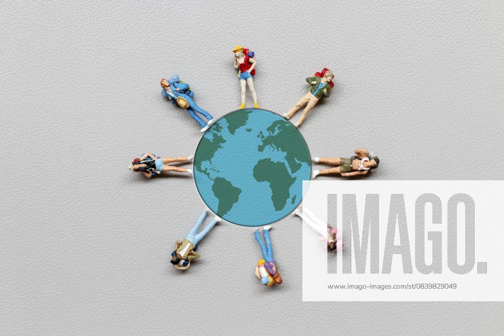 Miniaturmenschen stehen auf dem Globus mit grauem Hintergrund, Konzept zum Weltbevölkerungstag Miniature people standing on the globe with gray background, World Population Day concept