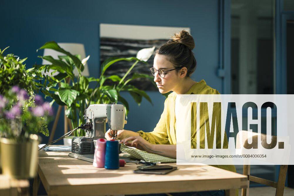IMAGO Creative: Digitale Welt, Verzicht auf Technologie Fashion designer working with sewing machine in her studio model released Symbolfoto property released MOEF01012