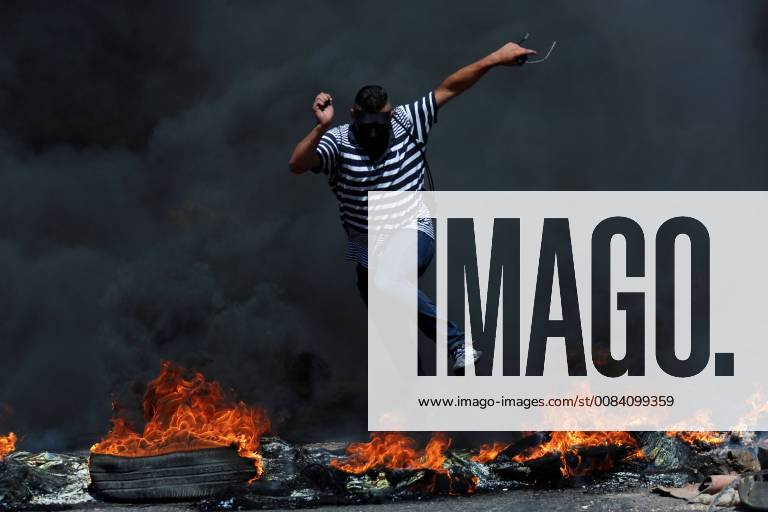 Ramallah, West Bank, Palestinian Territory - A masked Palestinian protester jumps up burning tires during clashes with Israeli troops following a demonstration near the Jewish settlement of Beit El, near Ramallah, in the occupied West Bank June 29, 2018 Ramallah Palestinian Territory - ZUMAap3_ 20180629_zaf_ap3_029