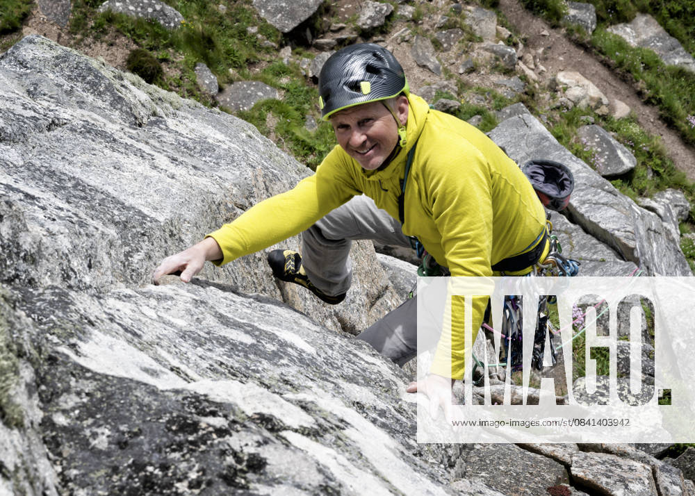 Climber ascending rocky mountain outdoors in Cornwall Bosigran model released, Symbolfoto, ALRF02185