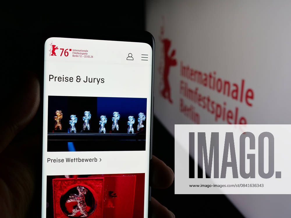 Photo illustration in Germany - 31 Oct 2025 In this photo illustration, a person is holding a smartphone with the webpage of Berlin International Film Festival Berlinale on screen in front of logo. Germany