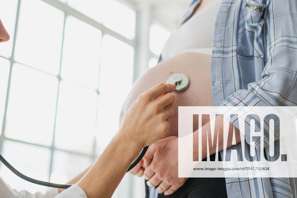Arzt untersucht schwangere Frau hält Stethoskop in der Nähe von großen Bauch hören Baby Herzschlag. Gynäkologe Arzt Beratung Patientin über Schwangerschaft im Krankenhaus Büro. Besuch beim Arzt medizinischen Checkup. Doctor examining pregnant woman holding stethoscope near big belly listening baby heartbeat. Gynecologist doctor consulting patient about pregnancy in hospital office. Visit to doctor medical checkup (License=RF) ,model released, Symbolfoto