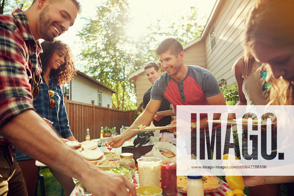 Dish, food and friends in backyard at barbecue with laughing, eating and bonding together. Happy, bbq and group of people with meal for social reunion, hangout or event outdoor at home on weekend model released property released