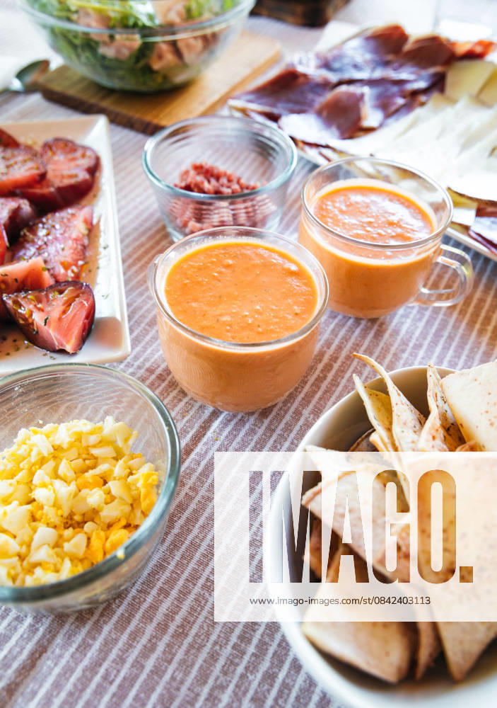 IMAGO Creative, Food, Tapas Delicious salmorejo served with various tapas including salad, ham, cheese, boiled eggs, and pita chips. Model Released SylviePm_ID32301_1100518_005