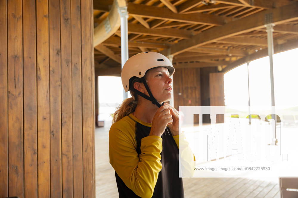 MR_ID31343_22933_DarioImitola.jpg, MR_ID31343_22932_SoniaFenoglio.jpg Woman secures her helmet while preparing for an adventurous kitesurfing session at Salinas del Rey, Antlantic, Colombia, highlighting proper safety measures. Model Released VictorCuenca_ID31343_1065766_001