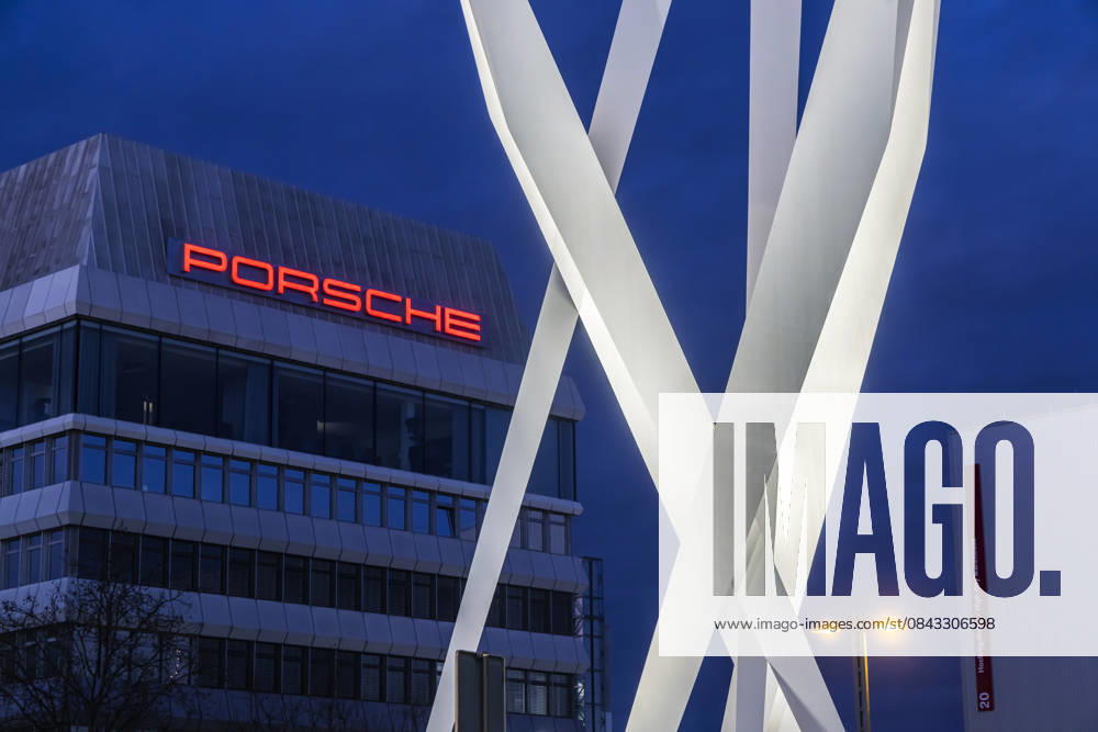 Porscheplatz in Zuffenhausen am Abend. Zwischen Porsche Museum und Hauptverwaltung das Kunstwerk Inspiration 911 von Gerry Judah. Drei Stelen, die in bis zu 24 Metern Höhe je einen Porsche 911 präsentieren. 19.12.2025. Stuttgart, Baden-Württemberg, Deutschland