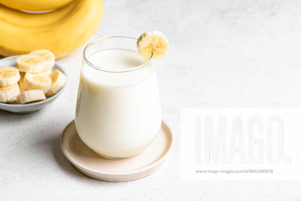 IMAGO Creative, Food, High Protein Frühstück Koreanische Bananenmilch Homemade banana milk. Glass of korean banana milk and banana slices on white background, copy space. (License=RF)