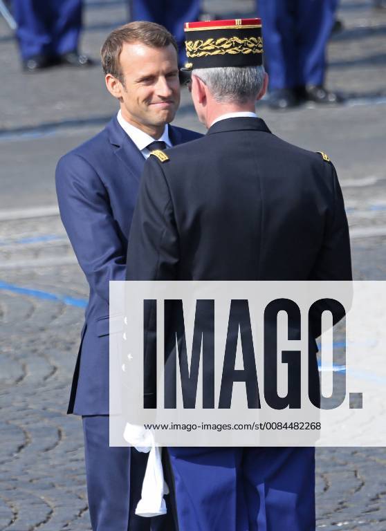 French President Emmanuel Macron speaks with a French military officer before the start of the annual Bastille Day military parade along Avenue des Champs-Elysees in Paris on July 14, 2018. PAR20180714042 DAVIDxSILPA