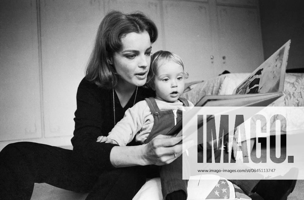 Romy Schneider sitzt mit ihrem Sohn David auf dem Boden und blättert gemeinsam mit ihm in einem Bilderbuch, 1968 in Paris. Paris Frankreich