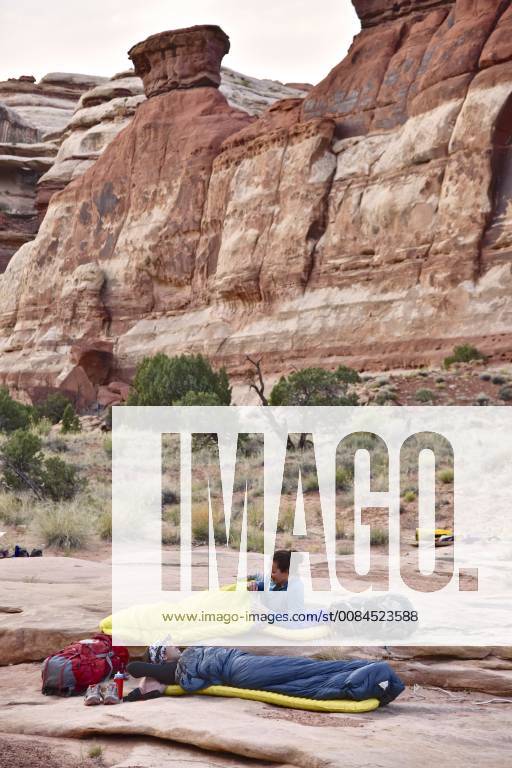 Side view of two women in sleeping bags while camping in Canyonlands National Park, Moab, Utah, USA, Moab UT USA HAMA001407 model released Symbolfoto