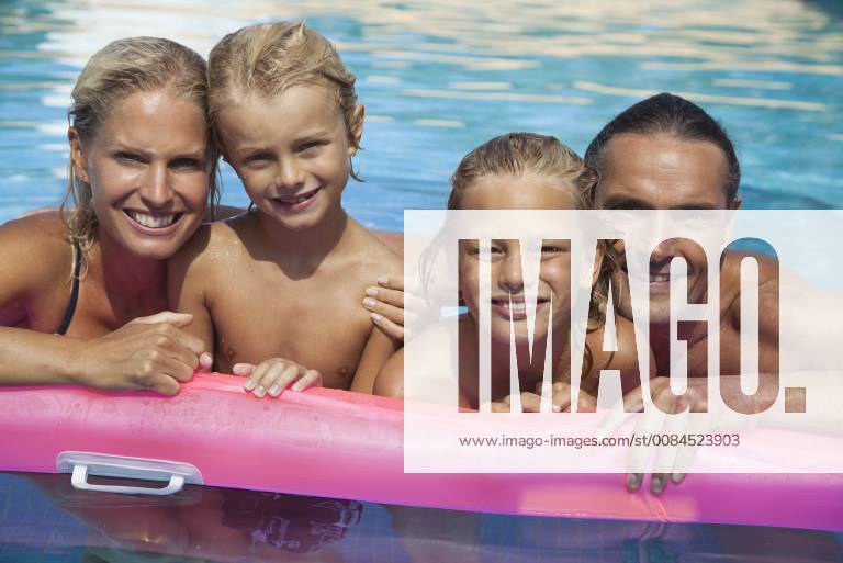 Family relaxing together in pool, portrait