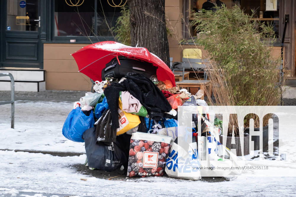 Obdachlos mit einem temporären Obdach aus Regenschirm, Tüten und Einkaufswagen auf der Strasse mitten im Schnee in Berlin am 7. Januar 2026. Alltag in Berlin