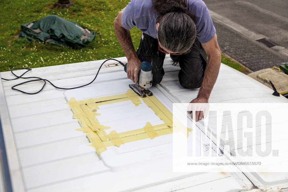 Umbau eines Camper Jumper Van zum Selbermachen. Neues Fenster draußen Schneiden mit einer elektrischen Stichsäge. Vorbereitung für die Installation eines Dachfensters DIY Camper Jumper van conversion. new window outside. cutting with an electric jigsaw. preparation for installing a top window