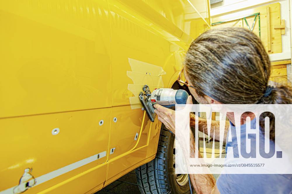 Umbau eines Camper Jumper Van zum Selbermachen. Außensteckdose für Wohnmobile. Schneiden mit einer elektrischen Stichsäge. Vorbereitung für die Installation einer externen 240 V Steckdose für Wohnwagen. Externer Netzstecker für Wohnmobile DIY Camper Jumper van conversion. motorhome electricity power outlet outside. cutting with an electric jigsaw. preparation for installing a Caravan external 240v socket. Camper RV External Power Plug