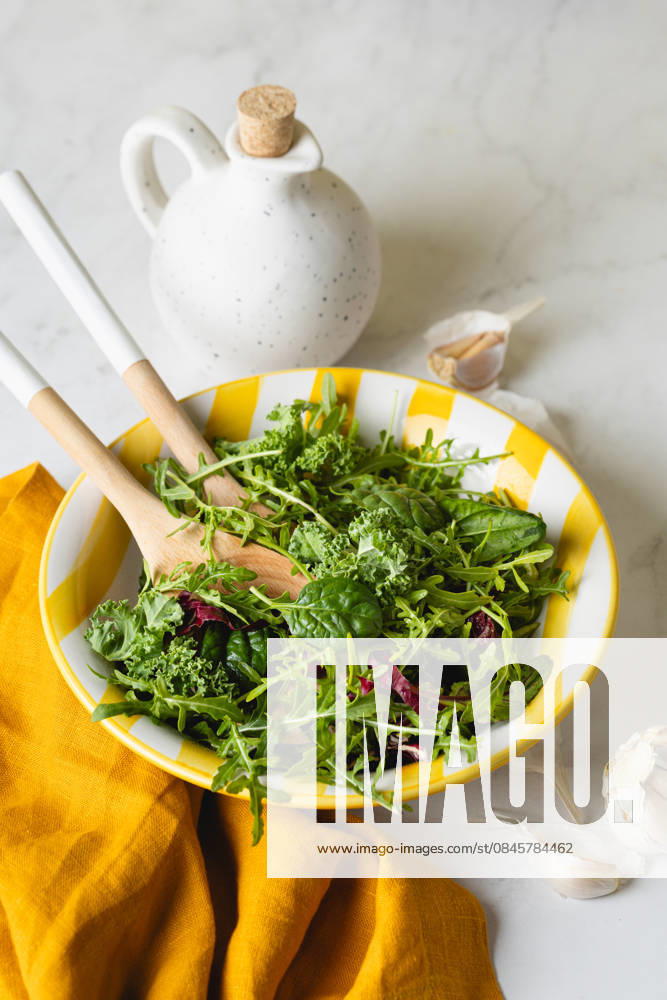 Fresh green salad leaves in a vibrant yellow plate A vibrant assembly of fresh green salad leaves served in a lively yellow plate. Perfectly illustrating healthy and home-cooked meal options, ideal for a nutritious diet. Model Released JuliaKuvaldina_ID32653_1112278_004