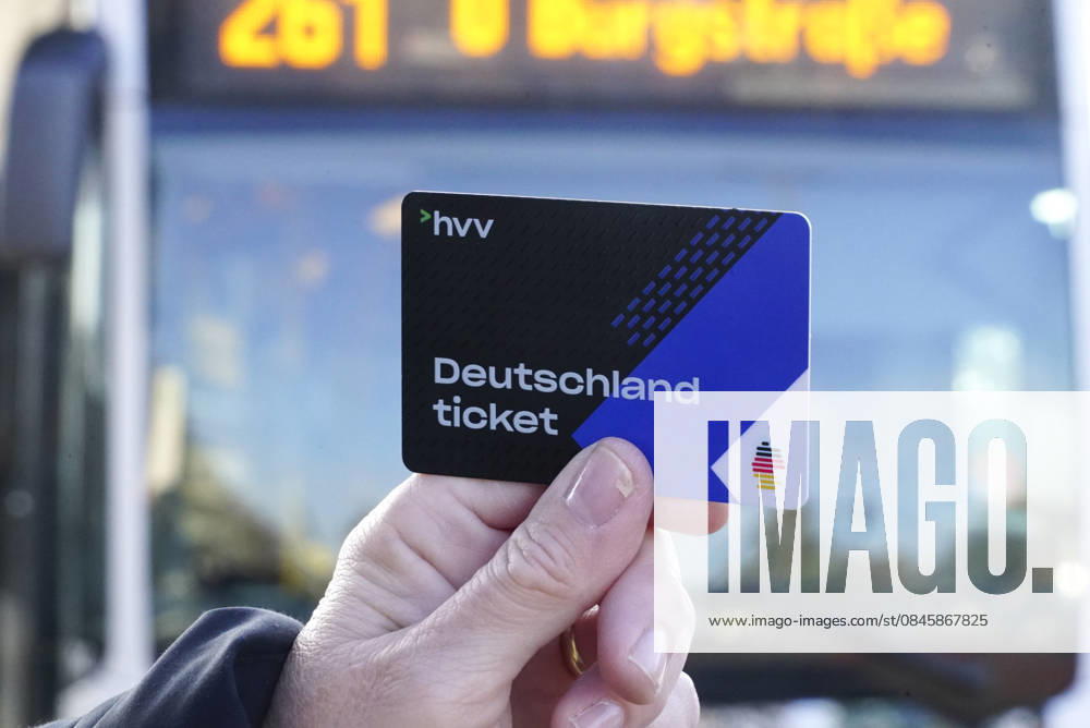 Cntv: Deutschlandtiket in der Hand vor HVV Bus und Bahnen Deutscxhe Bahn Deutschlandticket ist ein monatliches Abonnement für den gesamten deutschen ÖPNV OEPNV oeffentlichen Nahverkehr Busse, Straßenbahnen, U-Bahnen, S-Bahnen, REs, RB). Es kostet seit Januar 2026 63,00 Euro pro Monat und Fahrgast und gilt deutschlandweit Hamburg Germany